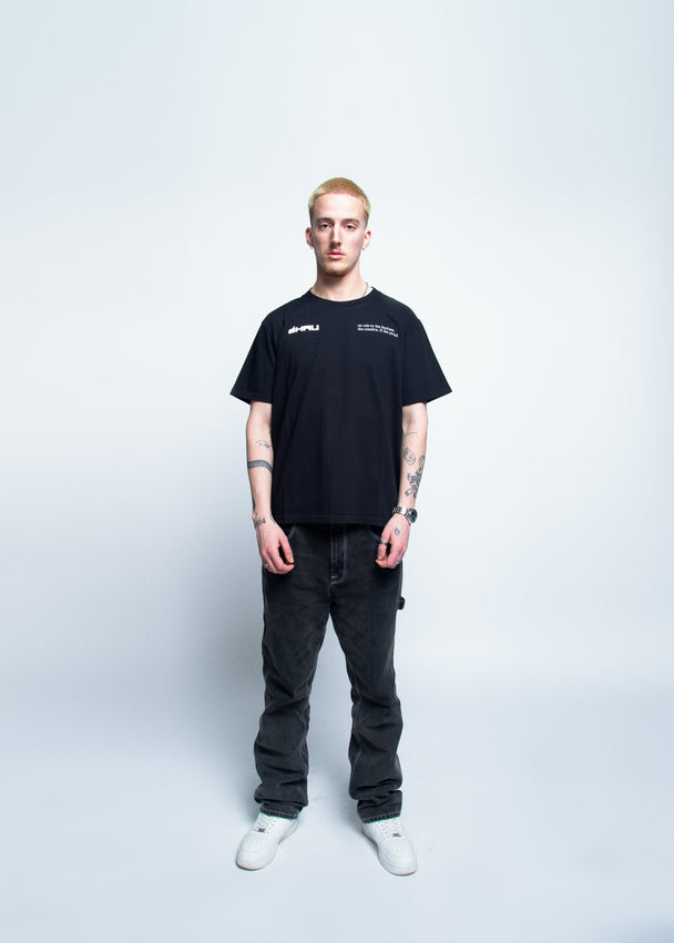 Person wearing a black t-shirt and dark jeans on a white background